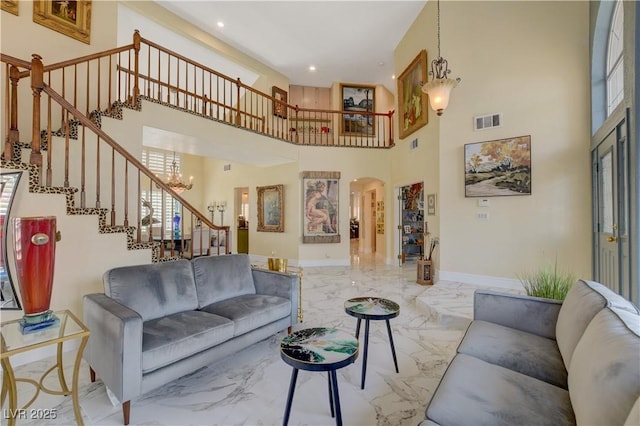 7613 Hackensack Ct, Las Vegas, NV 89128 - living area featuring marble tiled floors, arched walkways, a chandelier, stairway, and a high ceiling