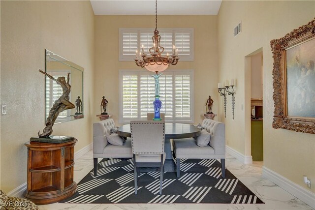 7613 Hackensack Ct, Las Vegas, NV 89128 - dining area featuring a chandelier, marble look tiles, and a high ceiling