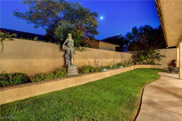 7613 Hackensack Ct, Las Vegas, NV 89128 - yard at night featuring a fenced backyard and a patio area