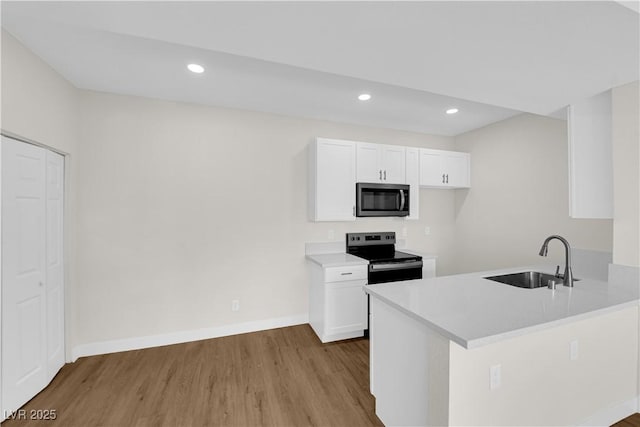 5174 S Jones Blvd Unit 105, Las Vegas, NV 89118 - kitchen featuring stainless steel microwave, electric range, wood finished floors, white cabinetry, and light countertops