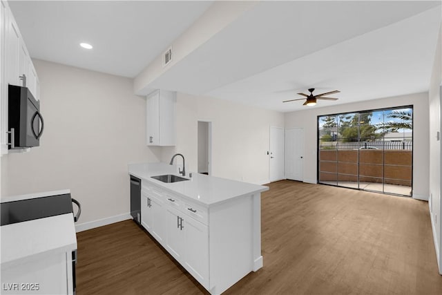 5174 S Jones Blvd Unit 105, Las Vegas, NV 89118 - kitchen with black microwave, a peninsula, stainless steel dishwasher, ceiling fan, and dark wood-type flooring