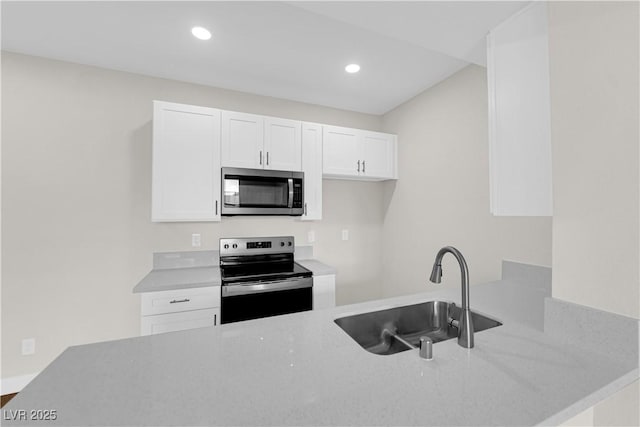 5174 S Jones Blvd Unit 105, Las Vegas, NV 89118 - kitchen with stainless steel microwave, black range with electric cooktop, white cabinets, recessed lighting, and light stone countertops
