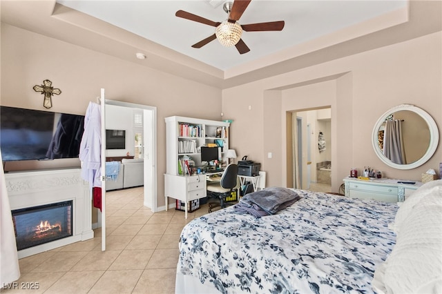 9136 Eagle Ridge Dr, Las Vegas, NV 89134 - bedroom with a raised ceiling, light tile patterned floors, an office area, a glass covered fireplace, and ceiling fan