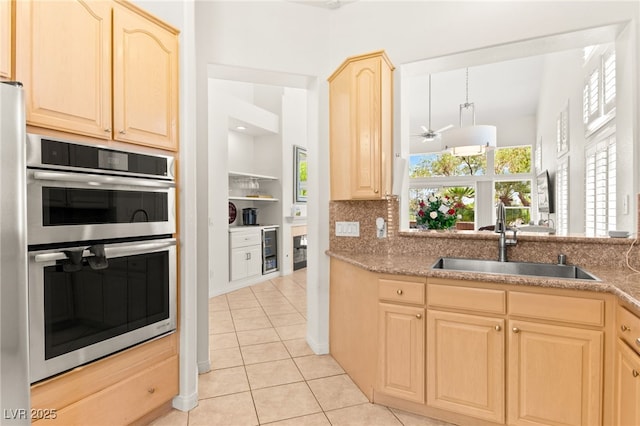 9136 Eagle Ridge Dr, Las Vegas, NV 89134 - kitchen with double oven, light brown cabinetry, light tile patterned floors, and a ceiling fan