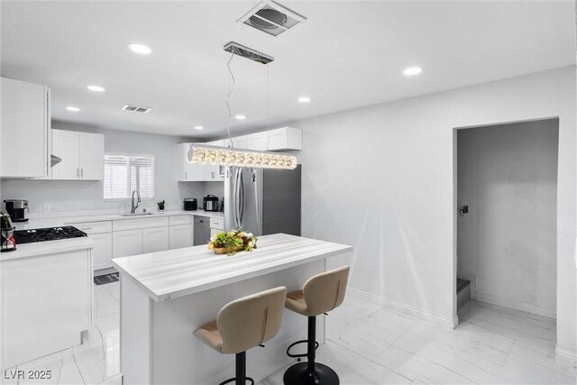 3361 Horizon St, Las Vegas, NV 89121 - kitchen with appliances with stainless steel finishes, light marble finish floors, recessed lighting, a kitchen breakfast bar, and light countertops