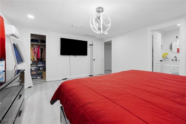 3361 Horizon St, Las Vegas, NV 89121 - bedroom with a wall mounted air conditioner, wood finished floors, recessed lighting, a spacious closet, and ensuite bath