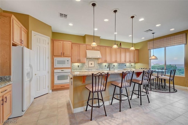 212 Florio Ct, Las Vegas, NV 89138 - kitchen featuring white appliances, under cabinet range hood, backsplash, light brown cabinets, and recessed lighting