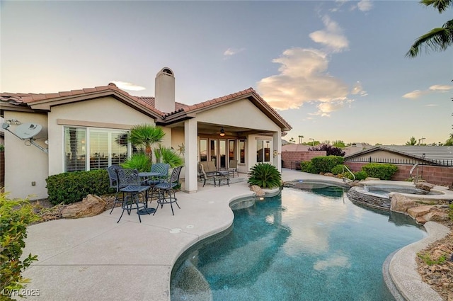 212 Florio Ct, Las Vegas, NV 89138 - pool at dusk featuring a fenced backyard, a patio area, ceiling fan, and a pool with connected hot tub