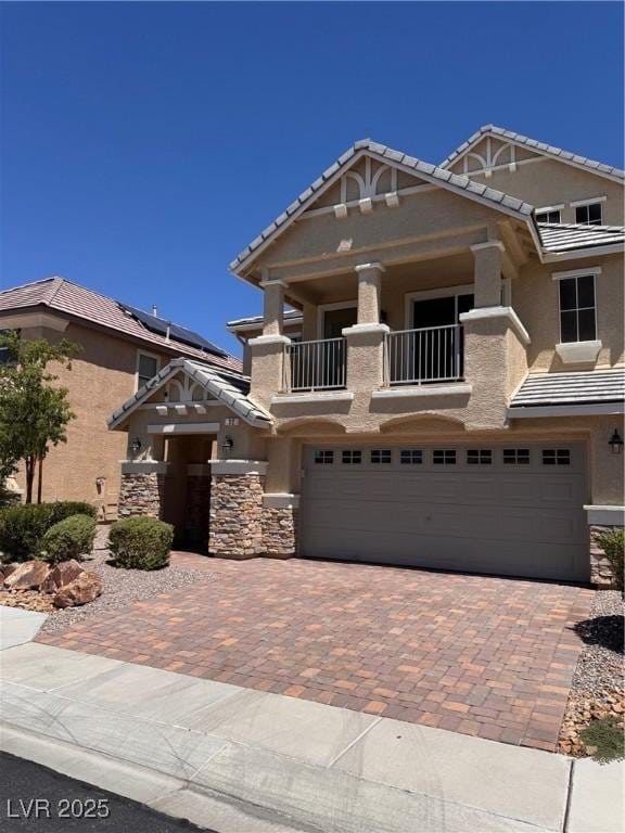 32 Yellow Peak Ave, North Las Vegas, NV 89031 - craftsman-style house with an attached garage, decorative driveway, stucco siding, and a balcony