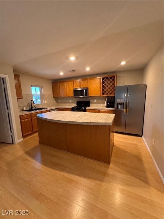 32 Yellow Peak Ave, North Las Vegas, NV 89031 - kitchen with appliances with stainless steel finishes, light wood-style floors, backsplash, tile counters, and recessed lighting