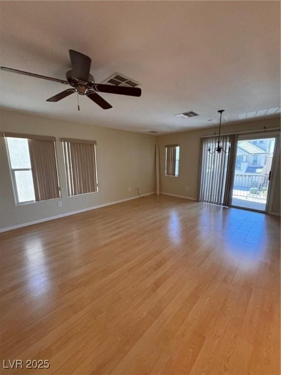 32 Yellow Peak Ave, North Las Vegas, NV 89031 - empty room with healthy amount of natural light, a chandelier, light wood finished floors, and ceiling fan