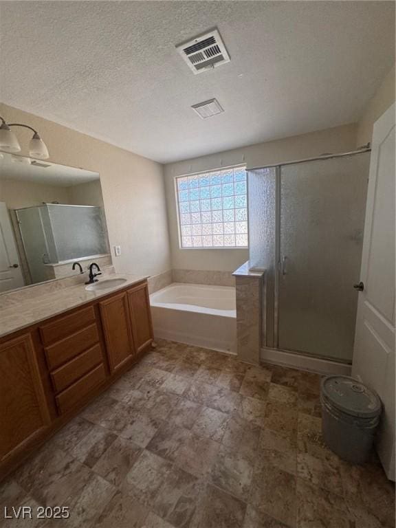 32 Yellow Peak Ave, North Las Vegas, NV 89031 - full bathroom featuring vanity, a garden tub, a stall shower, and a textured ceiling