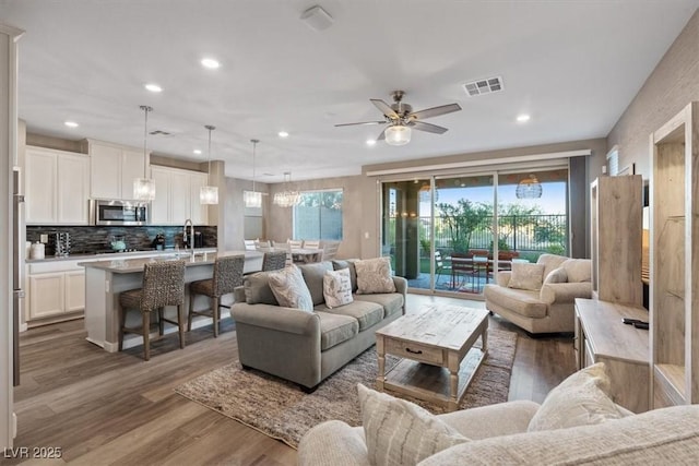 714 Rogue Wave St, Las Vegas, NV 89138 - living area featuring wood finished floors, plenty of natural light, ceiling fan, recessed lighting, and a chandelier