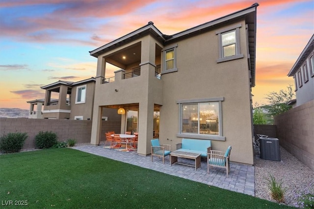 714 Rogue Wave St, Las Vegas, NV 89138 - back of property at dusk featuring a balcony, a fenced backyard, a patio, and stucco siding