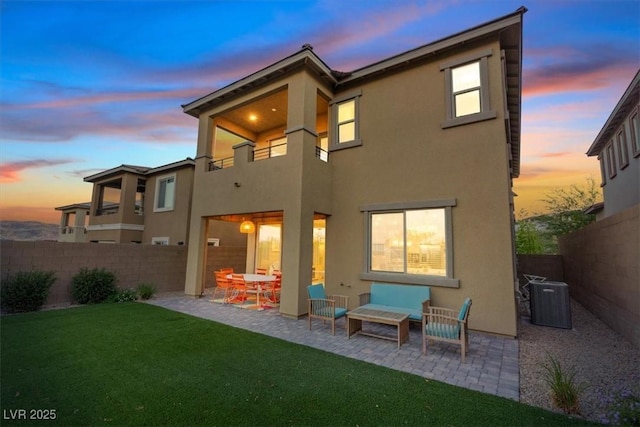 714 Rogue Wave St, Las Vegas, NV 89138 - back of property at dusk featuring a balcony, a patio area, a fenced backyard, and stucco siding