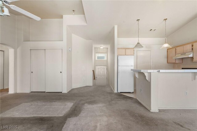 6201 E Lake Mead Blvd Unit 210, Las Vegas, NV 89156 - kitchen with freestanding refrigerator, tile countertops, light brown cabinetry, under cabinet range hood, and light carpet