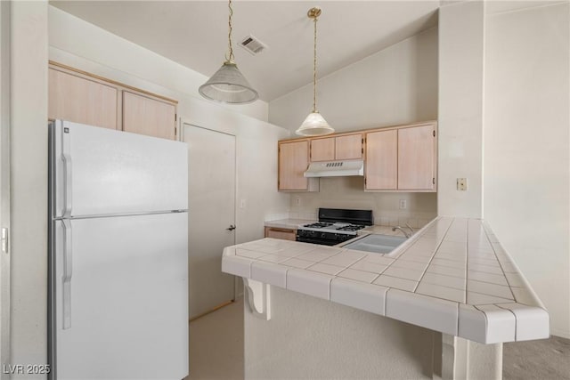 6201 E Lake Mead Blvd Unit 210, Las Vegas, NV 89156 - kitchen featuring white appliances, light brown cabinetry, under cabinet range hood, tile countertops, and a peninsula