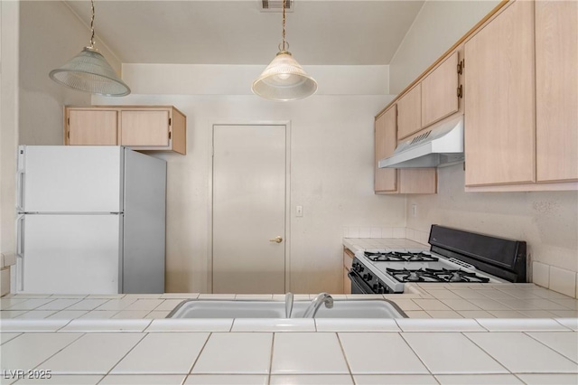 6201 E Lake Mead Blvd Unit 210, Las Vegas, NV 89156 - kitchen featuring white appliances, tile countertops, under cabinet range hood, light brown cabinetry, and hanging light fixtures