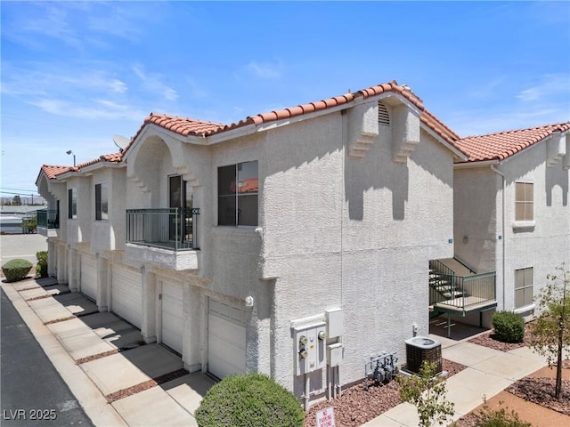 6201 E Lake Mead Blvd Unit 210, Las Vegas, NV 89156 - view of side of property featuring a balcony, stucco siding, a garage, and a tile roof