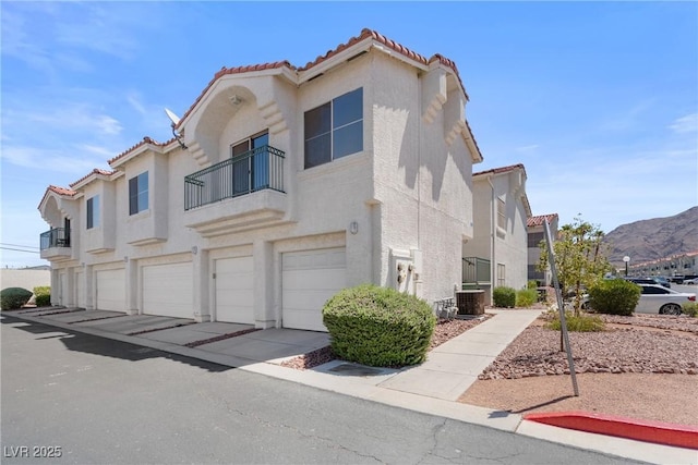 6201 E Lake Mead Blvd Unit 210, Las Vegas, NV 89156 - view of front of property with stucco siding, a tile roof, a garage, a balcony, and driveway