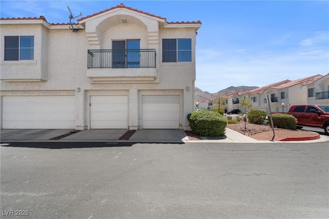 6201 E Lake Mead Blvd Unit 210, Las Vegas, NV 89156 - townhome / multi-family property featuring a balcony, stucco siding, a garage, a tile roof, and a residential view