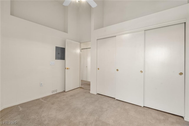 6201 E Lake Mead Blvd Unit 210, Las Vegas, NV 89156 - unfurnished bedroom with light colored carpet, a towering ceiling, a closet, electric panel, and a ceiling fan