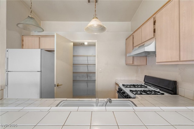 6201 E Lake Mead Blvd Unit 210, Las Vegas, NV 89156 - kitchen featuring white appliances, tile countertops, under cabinet range hood, light brown cabinetry, and pendant lighting