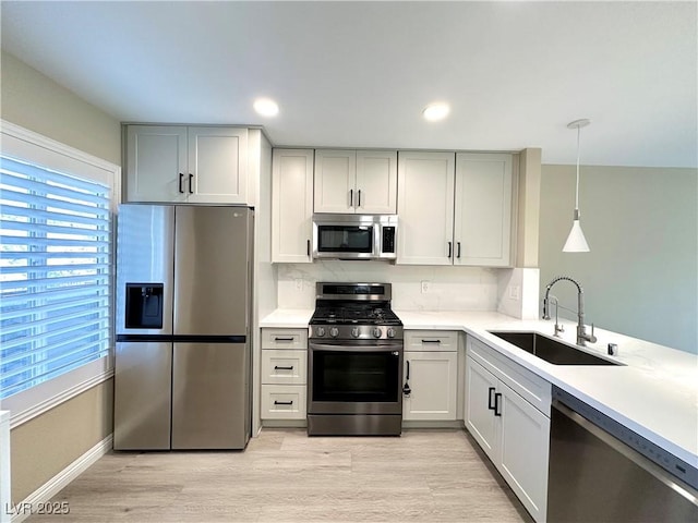 8070 W Russell Rd Unit 2070, Las Vegas, NV 89113 - kitchen featuring appliances with stainless steel finishes, light countertops, light wood-type flooring, tasteful backsplash, and pendant lighting