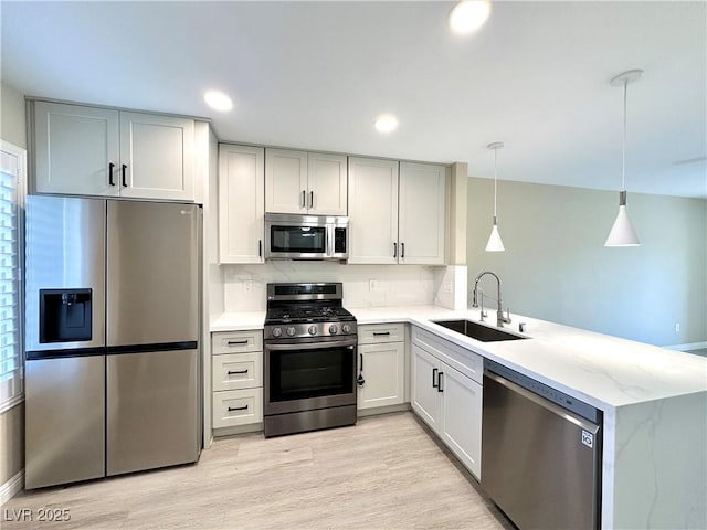 8070 W Russell Rd Unit 2070, Las Vegas, NV 89113 - kitchen with stainless steel appliances, a peninsula, light wood finished floors, light stone countertops, and decorative backsplash