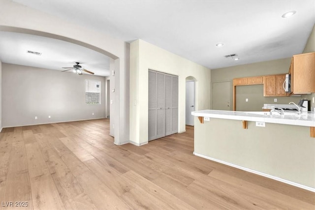 9948 Trailing Vine St, Las Vegas, NV 89183 - kitchen with arched walkways, ceiling fan, a peninsula, light wood-style flooring, and open floor plan