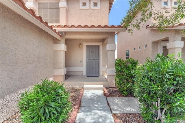 9948 Trailing Vine St, Las Vegas, NV 89183 - view of exterior entry with stucco siding and a tile roof