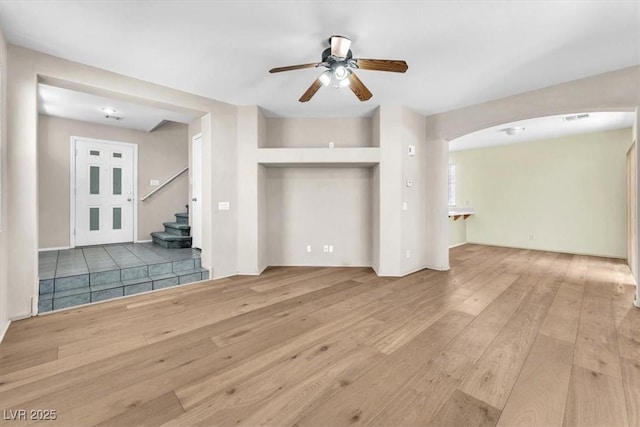 9948 Trailing Vine St, Las Vegas, NV 89183 - unfurnished living room with wood-type flooring, a ceiling fan, arched walkways, and stairs