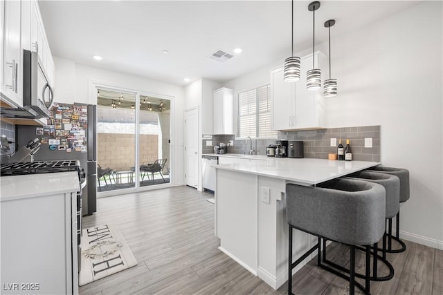 3447 Covilha Ln, Henderson, NV 89044 - kitchen featuring appliances with stainless steel finishes, light wood-style flooring, light countertops, backsplash, and recessed lighting