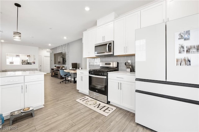 3447 Covilha Ln, Henderson, NV 89044 - kitchen with stainless steel appliances, open floor plan, light wood finished floors, tasteful backsplash, and recessed lighting