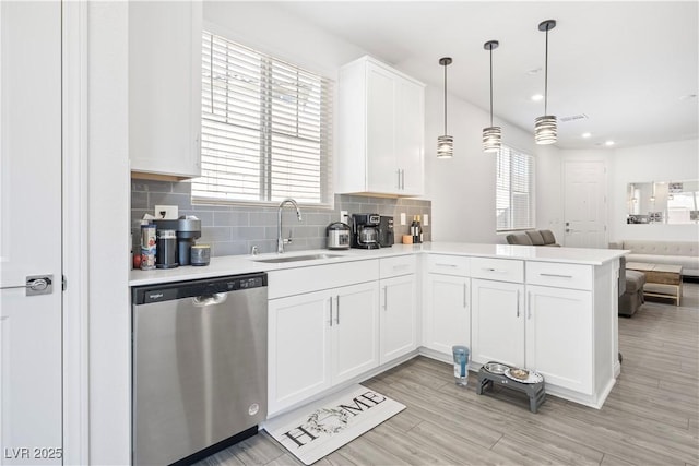 3447 Covilha Ln, Henderson, NV 89044 - kitchen with stainless steel dishwasher, open floor plan, light countertops, white cabinets, and a peninsula