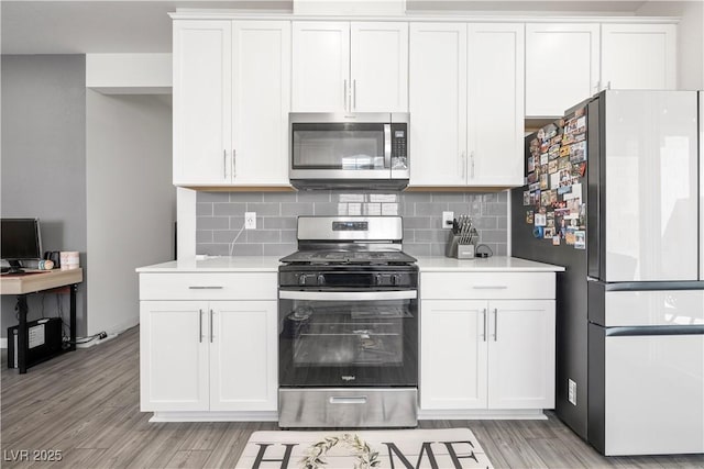 3447 Covilha Ln, Henderson, NV 89044 - kitchen featuring stainless steel appliances, light countertops, light wood-style flooring, white cabinets, and tasteful backsplash