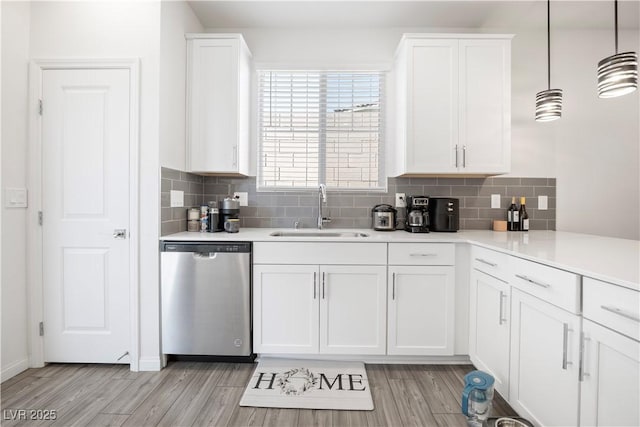 3447 Covilha Ln, Henderson, NV 89044 - kitchen featuring stainless steel dishwasher, light countertops, light wood-style floors, white cabinetry, and tasteful backsplash