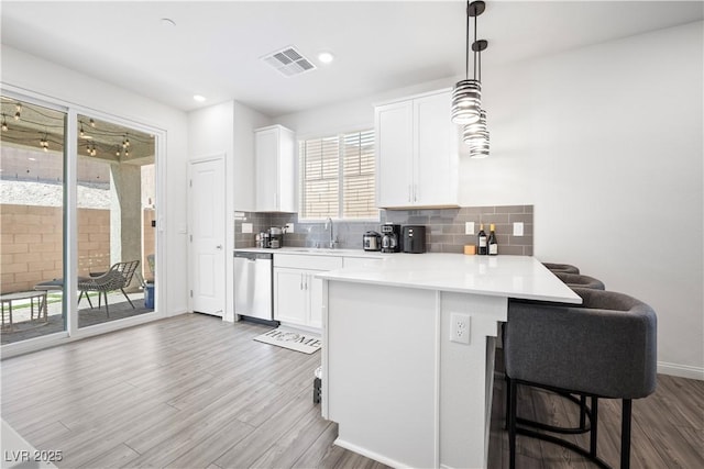 3447 Covilha Ln, Henderson, NV 89044 - kitchen with dishwasher, a peninsula, wood finished floors, white cabinetry, and recessed lighting