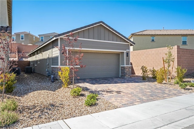 3447 Covilha Ln, Henderson, NV 89044 - view of front facade with stone siding, decorative driveway, a garage, and board and batten siding