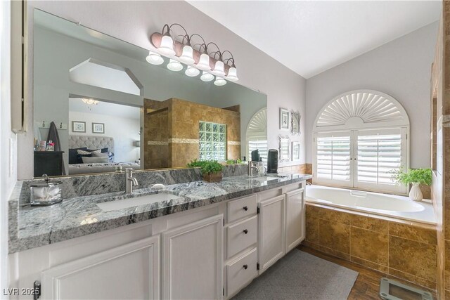 3024 Pier Harbor Dr, Las Vegas, NV 89117 - full bath with wood finished floors, vaulted ceiling, double vanity, a garden tub, and connected bathroom