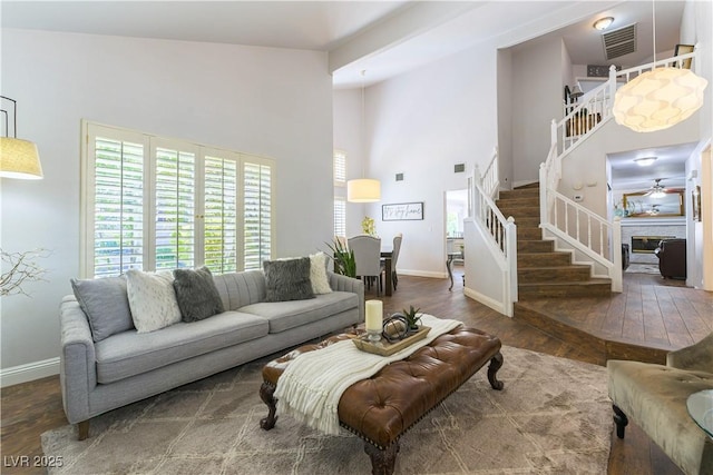 3024 Pier Harbor Dr, Las Vegas, NV 89117 - living room featuring stairs, wood-type flooring, a ceiling fan, and a high ceiling