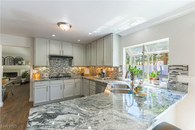 3024 Pier Harbor Dr, Las Vegas, NV 89117 - kitchen with light stone countertops, backsplash, dark wood finished floors, recessed lighting, and crown molding