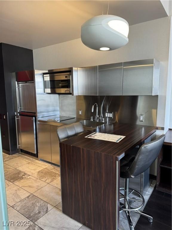 4381 W Flamingo Rd Unit 3708, Las Vegas, NV 89103 - kitchen featuring stainless steel microwave and tasteful backsplash