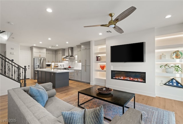2310 Malaga Peak St, Las Vegas, NV 89135 - living area featuring ceiling fan, light wood-style flooring, a glass covered fireplace, and recessed lighting