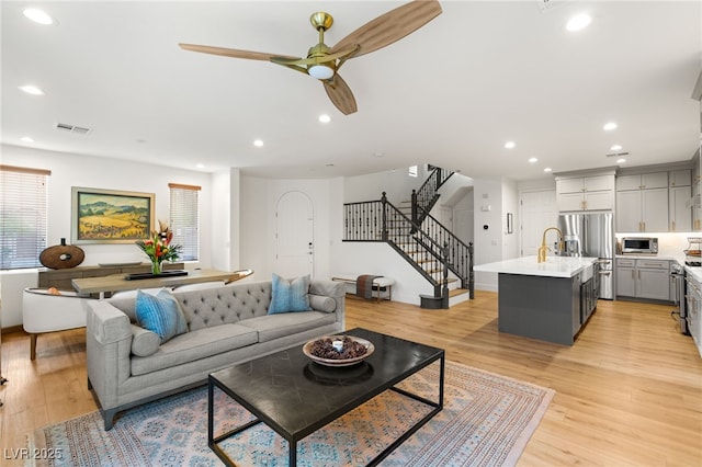 2310 Malaga Peak St, Las Vegas, NV 89135 - living area featuring stairs, a ceiling fan, healthy amount of natural light, light wood-style floors, and recessed lighting