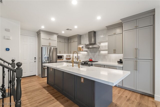 2310 Malaga Peak St, Las Vegas, NV 89135 - kitchen with appliances with stainless steel finishes, wall chimney range hood, gray cabinets, tasteful backsplash, and a kitchen island with sink