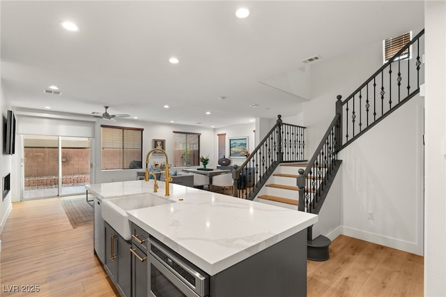 2310 Malaga Peak St, Las Vegas, NV 89135 - kitchen featuring recessed lighting, light wood-style flooring, ceiling fan, open floor plan, and light stone countertops