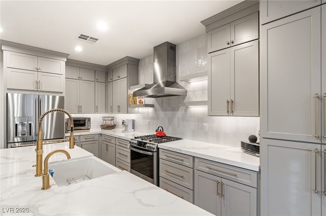 2310 Malaga Peak St, Las Vegas, NV 89135 - kitchen with wall chimney range hood, appliances with stainless steel finishes, gray cabinets, backsplash, and recessed lighting