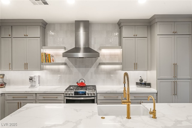 2310 Malaga Peak St, Las Vegas, NV 89135 - kitchen featuring gray cabinetry, wall chimney exhaust hood, gas range, tasteful backsplash, and recessed lighting