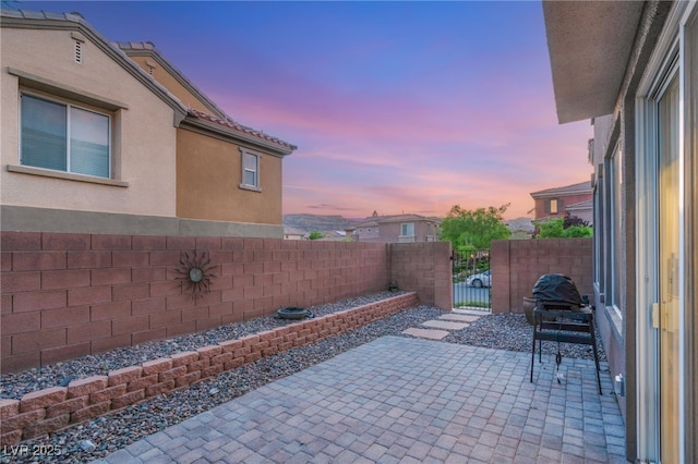 2310 Malaga Peak St, Las Vegas, NV 89135 - patio terrace at dusk featuring a fenced backyard, a patio, and a gate